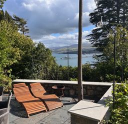 An outdoor area with deck chairs and a view of the water at Afallon Menai Bridge