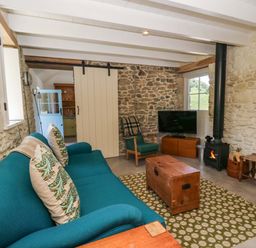 A living room with a sofa and coffee table at Dolwylan Barn in Cwmtydu near New Quay
