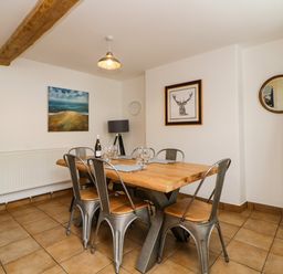 A dining room with a wooden table and six metal chairs at The Yellow House 13 King Street in Dawlish