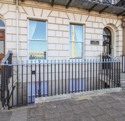 A building facade with two entrances and iron railings in front at Bliss On The Bay in Weymouth