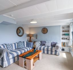 A living room with a sofa, coffee table, and television at 2 Cliff Cottages West Portholland near Gorran Haven