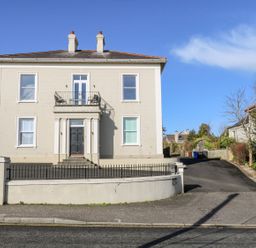 A two-story house with a side driveway and a small balcony at Sea Breeze in Ballycastle