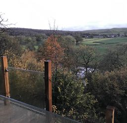 A view of a landscape with trees and a stream at The Sett on the Wharfe, Skipton