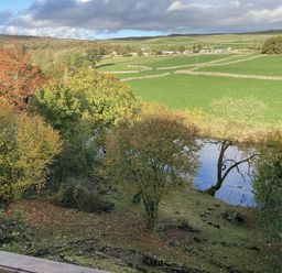 A view of a river and trees at The Sett on the Wharfe in Skipton