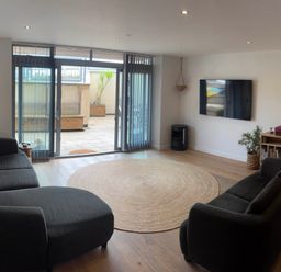 A living room with a sofa and television at Fistral Apres Surf in Newquay