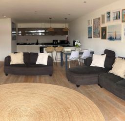 A living room with sofas and a dining area at Fistral Apres Surf in Newquay