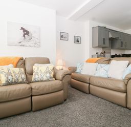 A living room with two sofas and wall decor at 76A Mackworth Road in Porthcawl