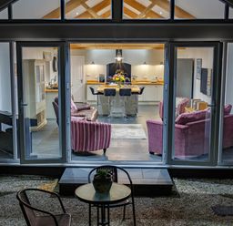 A living room and kitchen with chairs and a table outside at The Old Vicarage Retreat in Luxulyan
