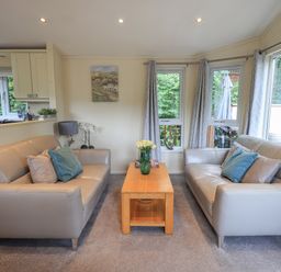 A living room with two gray sofas facing each other and a wooden coffee table in between at Acorn Bank Lodge L 55 Fallbarrow Park near Bowness-On-Windermere