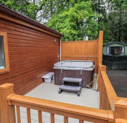 An outdoor area with a hot tub and wooden deck at Ridgway Lodge, Calgarth 40, White Cross Bay near Windermere