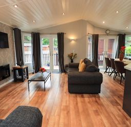 A living room with a sofa and dining table at Rydal Lodge Grasmere 24, White Cross Bay near Windermere