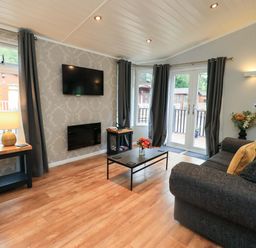 A living room with a sofa and television at Rydal Lodge Grasmere 24, White Cross Bay near Windermere
