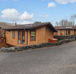 Two wooden cabins surrounded by stone walls at Elder Lodge Kirkstone 5 Limefitt Park near Windermere