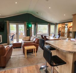 A living room with a sofa and television at Elder Lodge Kirkstone 5 Limefitt Park near Windermere