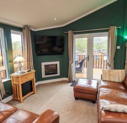 A living room with a sofa and television at Elder Lodge, Kirkstone 5, Limefitt Park near Windermere