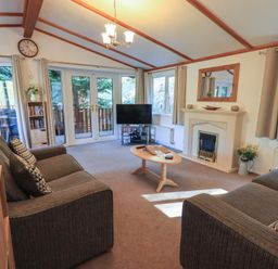 A living room with two sofas a coffee table a television and a fireplace at Walkers Retreat Lodge Fellside 5 Limefitt Park near Windermere