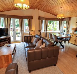 A living room with a sofa and television at Birthwaite Lodge Fellside 6 Limefitt Park near Windermere