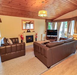 A living room with seating and a fireplace at Birthwaite Lodge, Fellside 6, Limefitt Park near Windermere