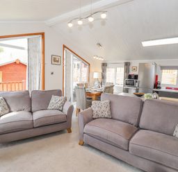 A living room with two sofas and a dining table next to a kitchen at Limefitt Lodge Fellside 8 Limefitt Park near Windermere