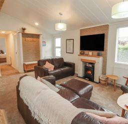 A living room with a sofa and television at Beech Grove Lodge Glade 17, Fallbarrow Park near Bowness on Windermere