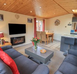 A living room with sofas and a coffee table beside a dining area at Striding Edge Lodge Ullswater 9 Limefitt Park near Windermere