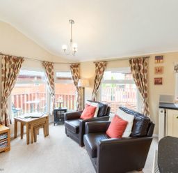 A living room with two leather chairs and patterned curtains at Hideaway Lodge Kirkstone 14 Limefitt Park near Windermere