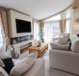A living room with sofas a coffee table a television and a fireplace at Valley View Lodge Wansfell 10 Limefitt Park near Windermere