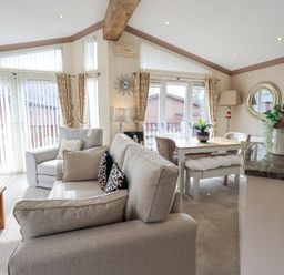 A living room with sofas a dining table and a kitchen counter at Valley View Lodge in Wansfell 10 Limefitt Park near Windermere