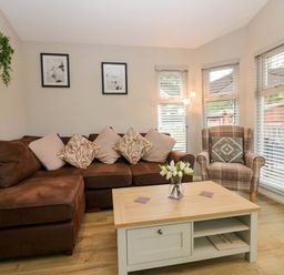 A living room with a sofa and coffee table at Badgers Hollow Lodge, Grasmere 30, White Cross Bay near Windermere