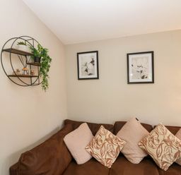 A living room with a sofa and wall art at Badgers Hollow Lodge in Grasmere 30, White Cross Bay near Windermere