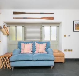A living room with a sofa and cushions at Scilly Stack in St Just