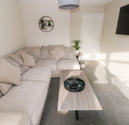 A living room with a sofa and coffee table at Westwinds in Tenby