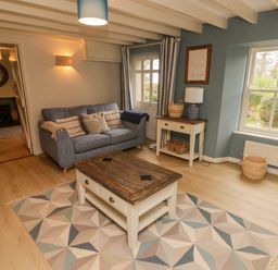 A living room with a sofa wooden coffee table and side table with lamp at Sea View in Newport Pembrokeshire