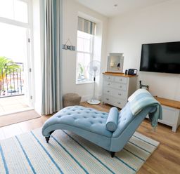 A living room with a chaise lounge and television at 4 The Beaches in Weymouth