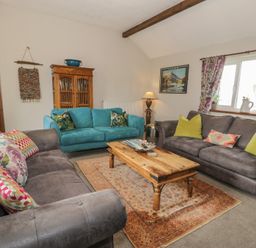 A living room with sofas and a coffee table at Orsedd Wen Cottage Betws-Y-Coed