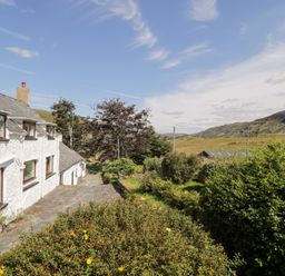 A house with a garden and hills in the background at Cwm, Capel Curig