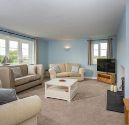 A living room with sofas coffee table and television at Overbrook in Salwarpe near Droitwich Spa