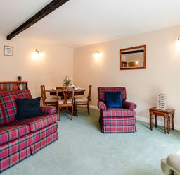 A living room with sofa and dining table at Lupin Cottage in Akeld near Wooler