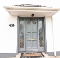 The front entrance door with windows on both sides and a doormat at 17 Clover Hill in Killorglin County Kerry