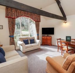 A living room with sofas a television and a dining table at The Columbine in Akeld near Wooler