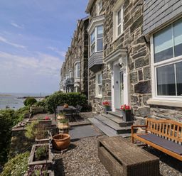 An outdoor area with a stone wall and a bench at 5 Porkington Terrace in Barmouth