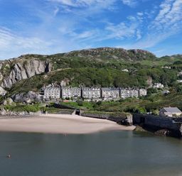 A beach with hotel buildings beside water at 5 Porkington Terrace Barmouth