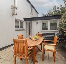 An outdoor area with a dining table and chairs at Wrens Nest in Slapton
