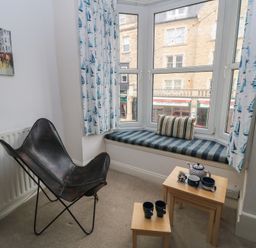 A living room with a window seat and tea set at Still Waters in Swanage