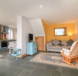 An open living area with a kitchen diner on the left and a sitting area on the right at Hill Coach House in Watchet