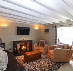 A living room with a sofa and armchairs at 4 Bryn Llan Aberdaron