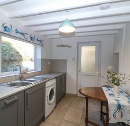 A kitchen with a sink and washing machine at 4 Bryn Llan Aberdaron