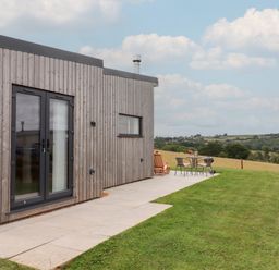 An outdoor space with a cabin and seating area at The Cadeleigh near Tiverton