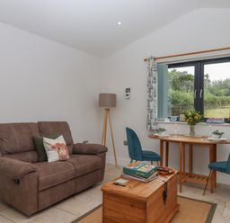 A snug with a sofa and table at The Pennymoor in Cadeleigh near Tiverton