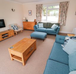 A living room with two blue sofas a wooden coffee table and TV at Trem Y Morfa in Newport Pembrokeshire